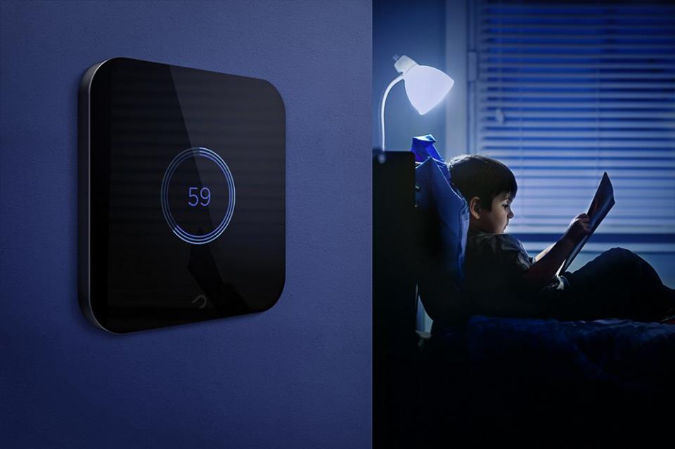 Chłopiec czytający książkę przy lampce oraz dotykowy ściemniacz światła na ścianie.