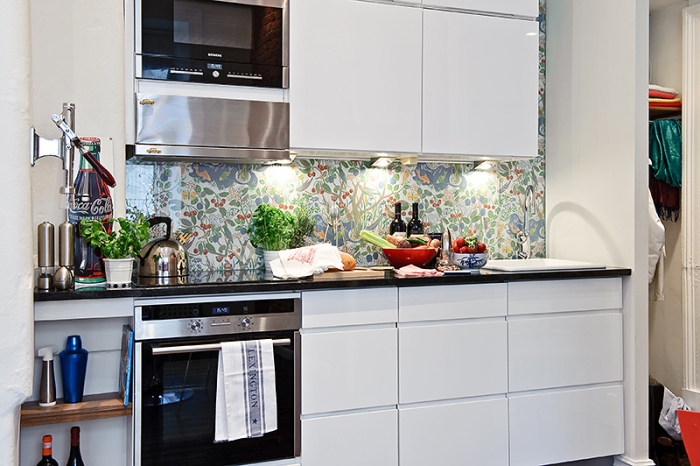 Kawalerka z kuchnią urządzoną w sposób liniowy.