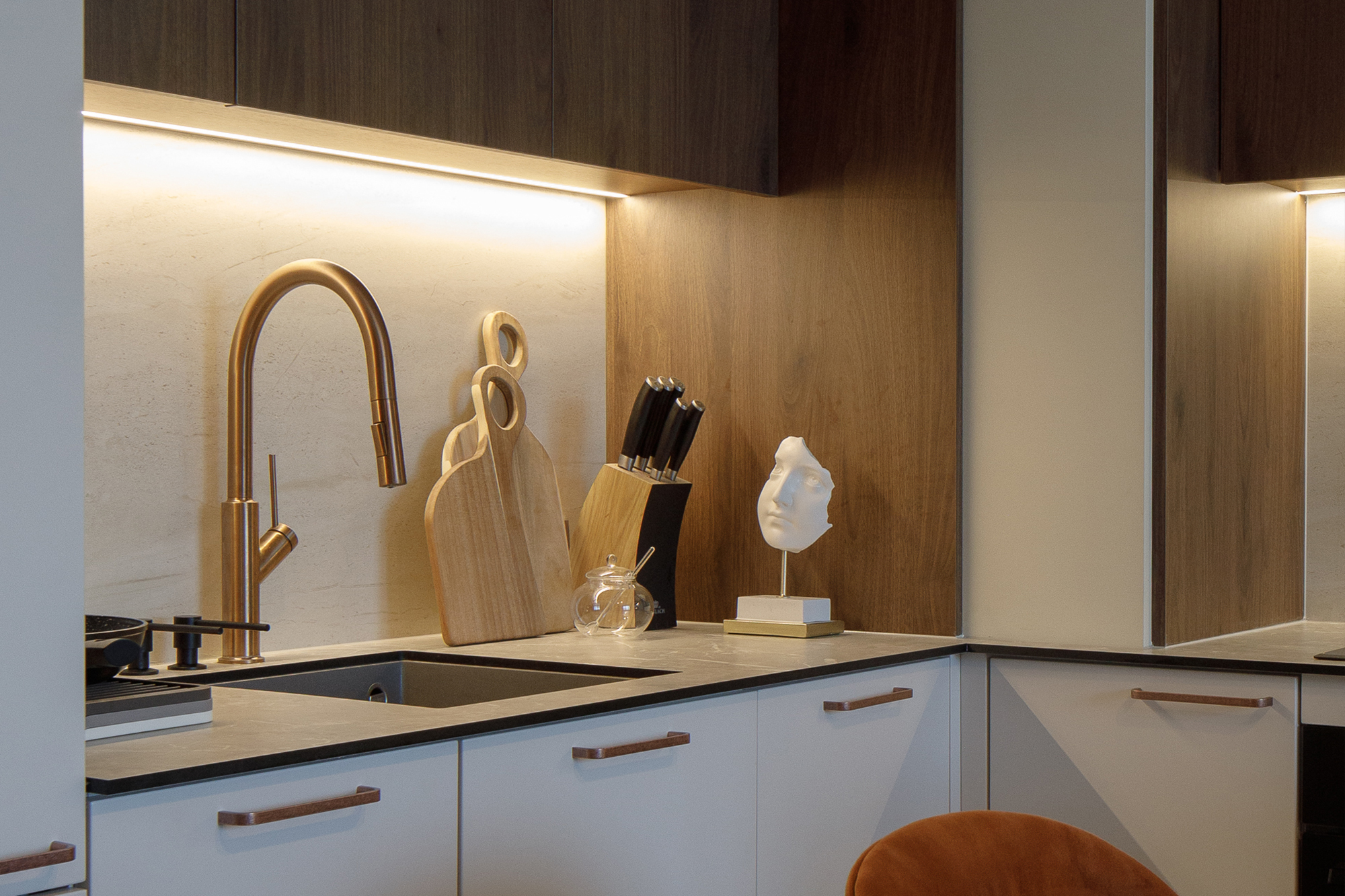 Drewniane fronty i miedziane basterie w nowoczesnej kuchni w pierwszym mieszkaniu młodej pary